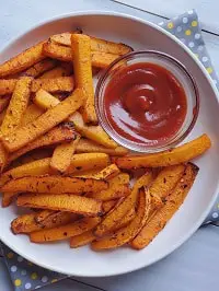 air fryer butternut squash fries served in a white plate with ketchup