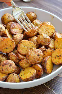 air fryer baby gold potatoes in a white bowl with a fork