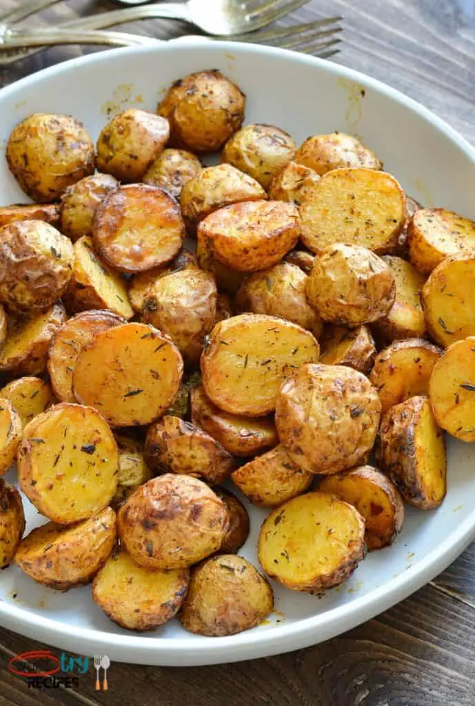 air fryer baby gold potatoes in a white plate with forks at the background