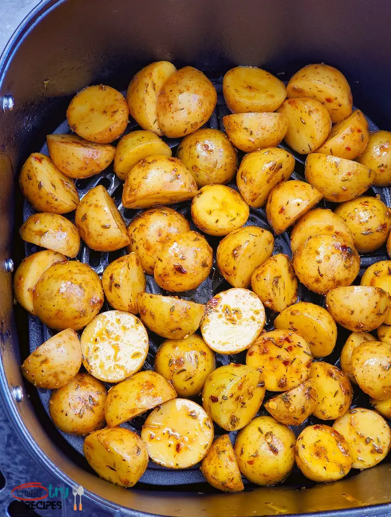 well seasoned halved baby potatoes in the air fryer basket
