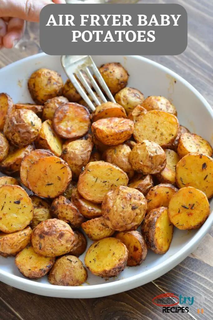 air fryer roasted baby potatoes in a white plate and being lifted with a fork