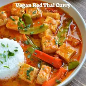 vegan vegetarian red thai curry with tofu served with white rice in a white plate