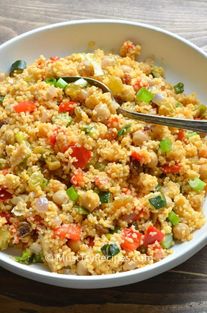 instant pot vegetable couscous in a white plate with a spoon