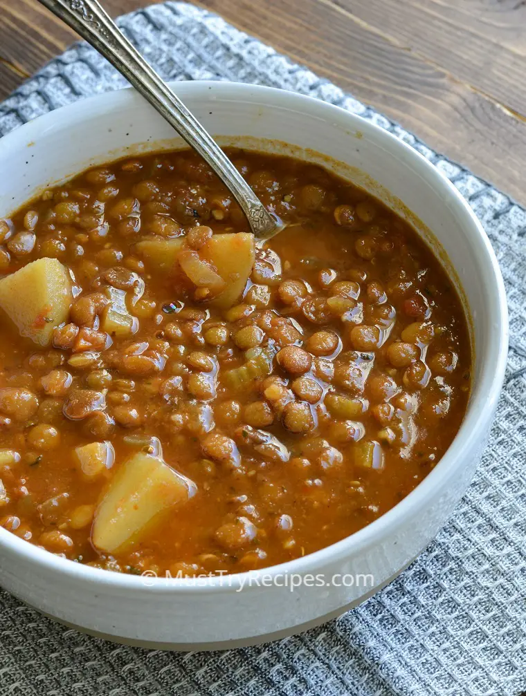 Best instant pot lentil soup with a silver spoon in a white bowl