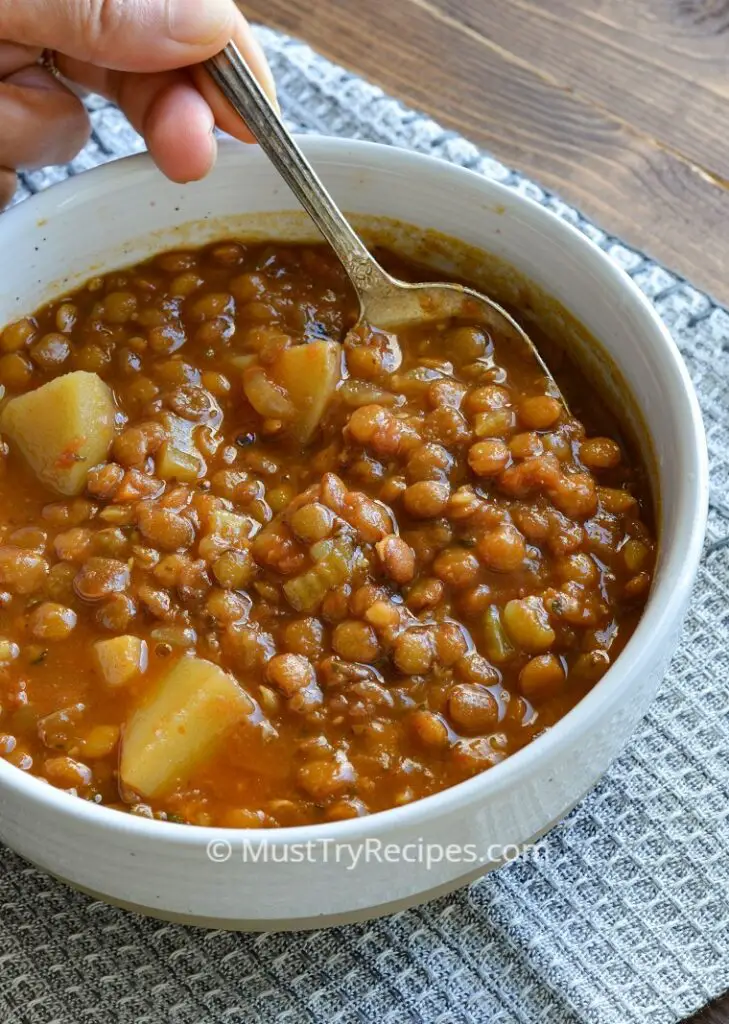 instant pot lentil soup with potatoes served in a white bowl with a spoon