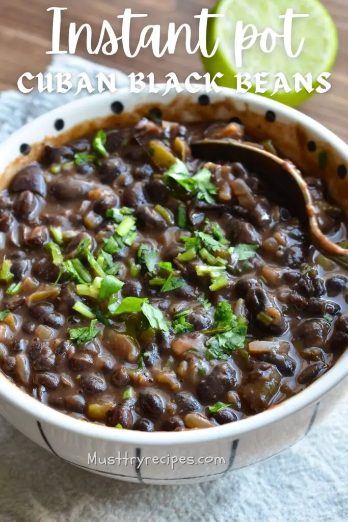 Vegan Cuban black beans garnished with chopped cilantro and served in a white bowl