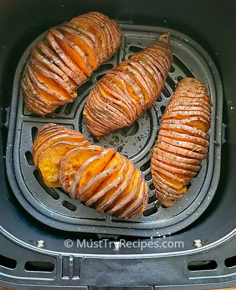 air fryer hasselback sweet potatoes in an air fryer basket