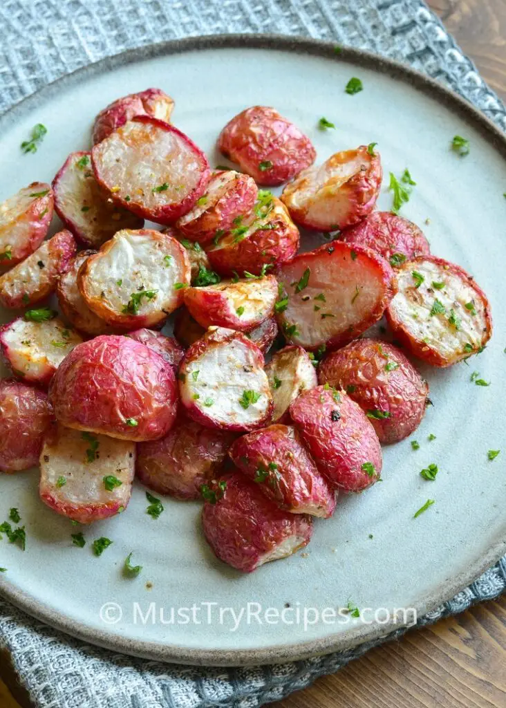 air fryer roasted radishes on a plate garnished with fresh parsley