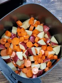 diced potatoes and carrots in air fryer basket