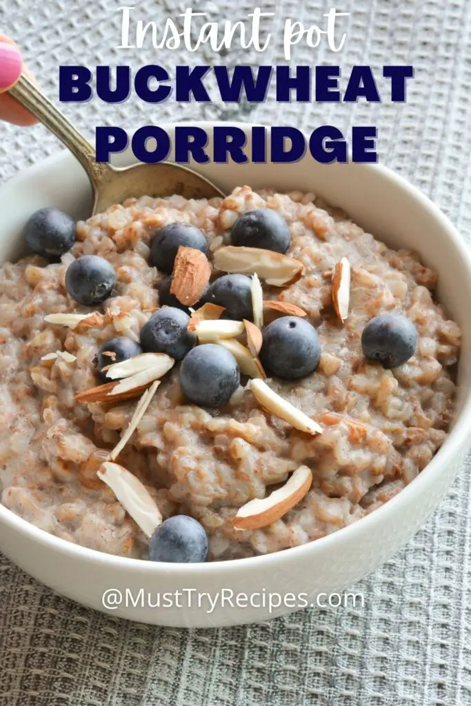buckwheat porridge in a white bowl with a spoon topped with blueberries and almonds