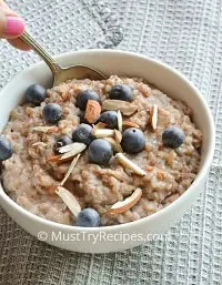 instant pot buckwheat porridge in a white bowl with spoon