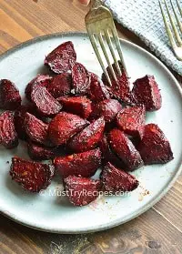 roasted beets in a grey plate with a fork