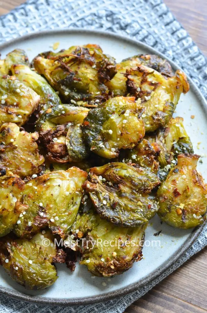 roasted smashed brussel sprouts on a grey plate