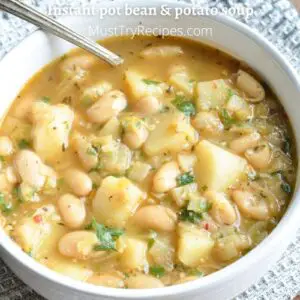 bean and potato soup in a white bowl with a spoon