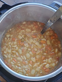 lima beans soup in instant pot with a ladle