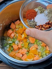 adding seasonings to the sauteed veggies