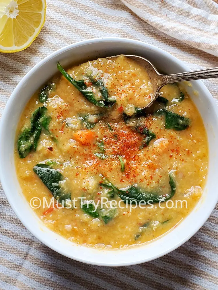 simple red lentil soup in a white bowl garnished with paprika