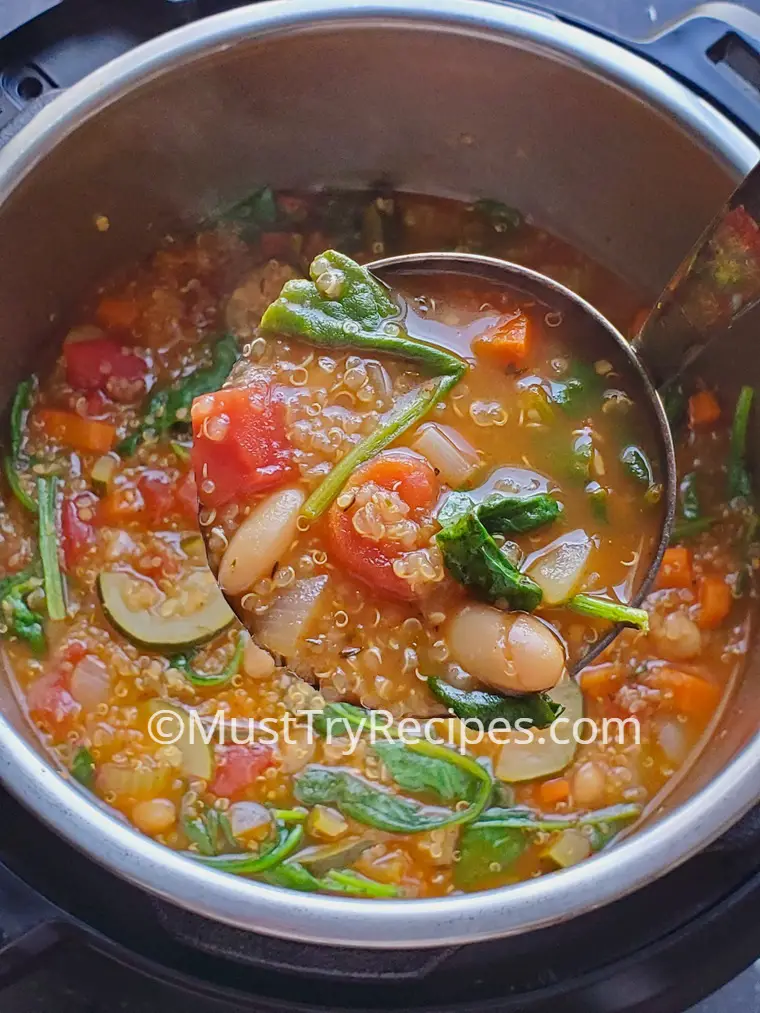 quinoa soup with vegetables in a ladle