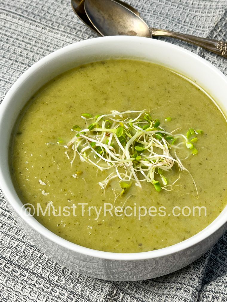 lettuce soup garnished with microgreens in a white bowl